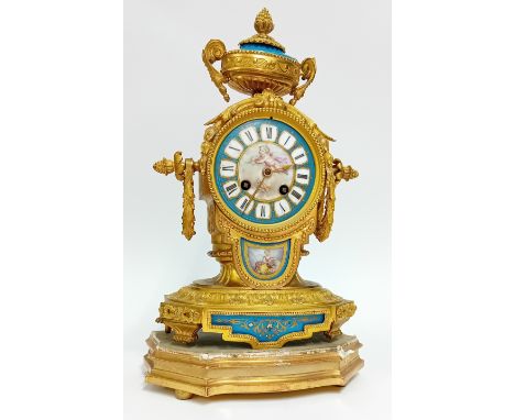 A 19th century French gilt brass mantle clock in Louis 15th style, with Sevres style painted porcelain dial and panels of fol