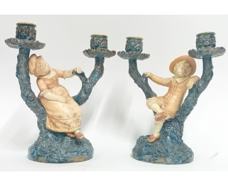A pair of late 19th century Royal Worcester candlesticks, marked 1125, of tree form with boy and girl figures in period count