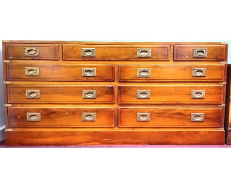 A yew campaign style sideboard, with recessed brass handles in nine drawers, on a plinth base, height 70cm x 150cm, together 