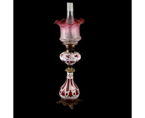 Victorian opaque overlaid ruby glass oil lamp, gilt metal mounts, pear-shape base on lion paw feet, 46cm, complete with chimn