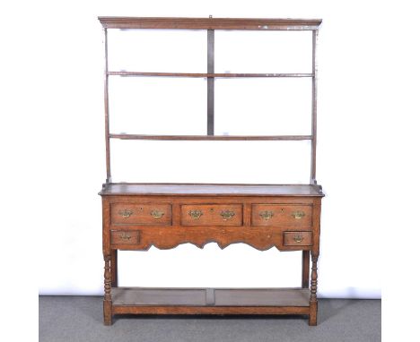 Oak dresser, early 19th Century, two shelf delft rack, under an ogee moulded cornice, the base with five drawers, over a shap