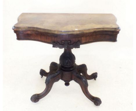 A Victorian walnut fold top card table on carved column and quadruple scroll supports