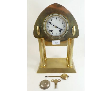 A French Art Nouveau gilt metal mantel clock with striking movement, the pointed arch top over enamel dial, all resting on fo