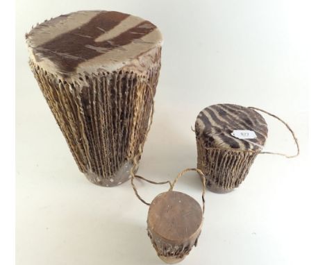 A set of three graduating African hide bongo drums, largest 32cm tall