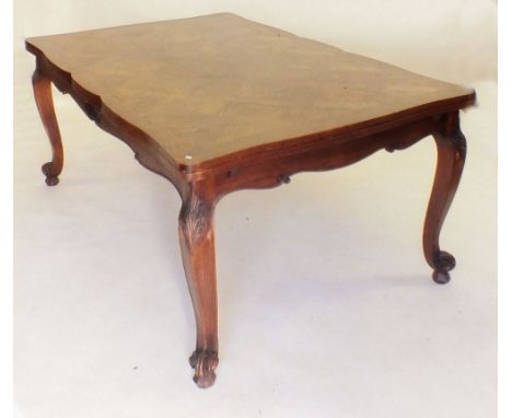 A 20th century oak dining suite comprising large draw leaf dining table with four cabriole supports carved foliage and scroll