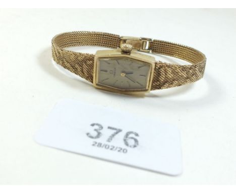 An Omega 9 carat gold ladies wrist watch with textured strap in original box, 19.5g total weight