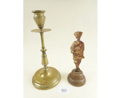 A painted wooden figure of a WWI Indian soldier on weighted base together with Army and Navy Stores brass candlestick