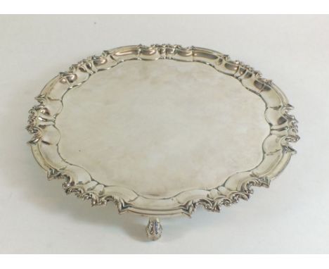 A silver pie crust edge salver on scroll feet - 26cm dia, by William Hutton and Sons, London 1909 - 585g