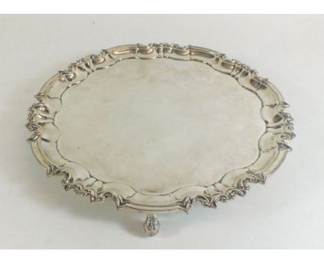 A silver pie crust edge salver on scroll feet - 26cm dia, by William Hutton and Sons, London 1909 - 585g