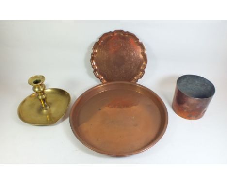 Three copper trays, a copper pot and a brass chamber stick