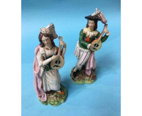 A pair of Staffordshire figures of a Man and Woman playing a Lute