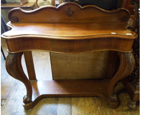 A Victorian oak console table, with a serpentine front and leaf carved cabriole legs, 122 cm wide