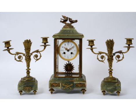 A French clock garniture, the clock having an 8.5 cm diameter enamel dial with Arabic numerals, fitted an eight day movement,