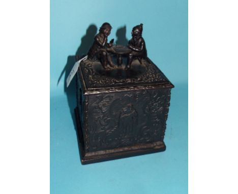 A cast iron tobacco box, the cover decorated two figures playing cards, 19 cm high