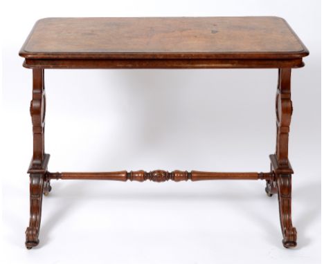 A Victorian walnut table, by Gillow, the top veneered in burr walnut, on shaped end supports joined by a turned and carved po