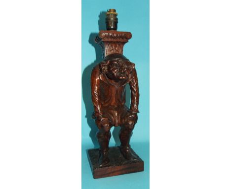 A Black Forest style carved table lamp base, in the form of a crouching man, 38.5 cm high