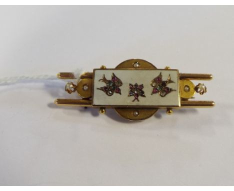 An Aesthetic period yellow coloured metal, enamel and gem set brooch