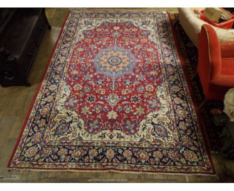 A Persian style carpet, with a central medallion on a red ground, within a multi border, 345 x 220 cm