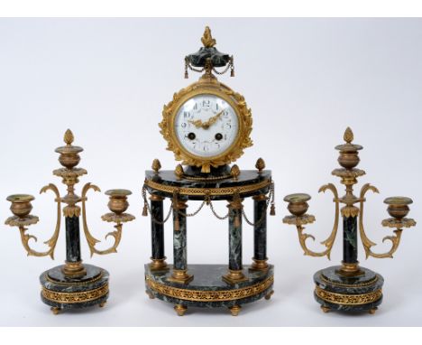 A Louis XVI style gilt brass clock garniture, the clock having an 8.5 cm diameter enamel dial with Arabic numerals, fitted an