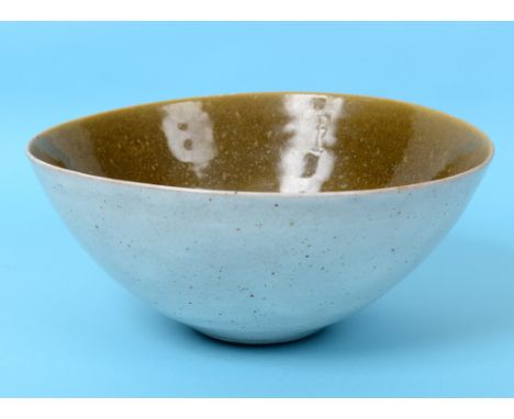 A Lucie Rie pottery bowl, of irregular oval form, with a variegated green/brown glaze to interior and a white and brown speck