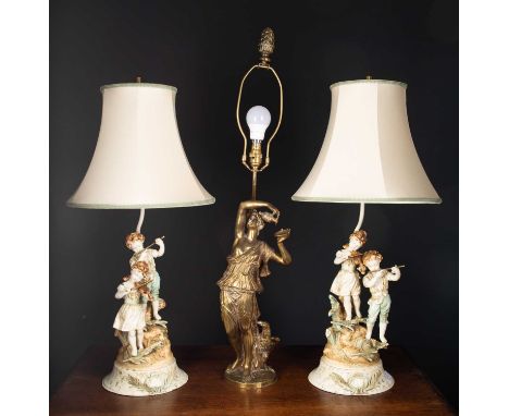 A brass table lamp in the form of a sculpture after Clodion of a classical maiden, 59cm high to the light fitting together wi