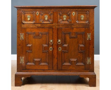 An antique oak side cabinet with two frieze drawers above two panelled doors and raised on bracket feet, 103cm wide x 57cm de