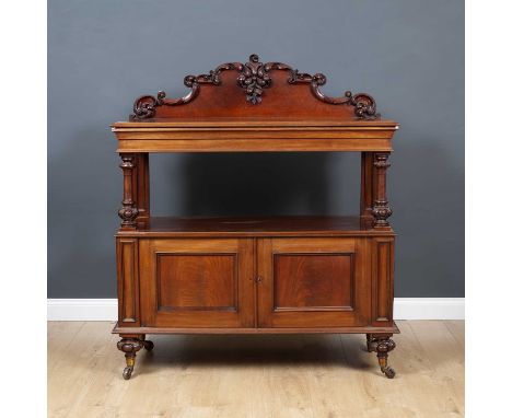 A Victorian Mahogany buffet with a carved and raised back, a single frieze drawer, turned supports and two panelled doors, on