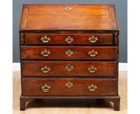A George III mahogany bureau the fall front enclosing a fitted interior with pigeon holes and drawers, all above four long dr