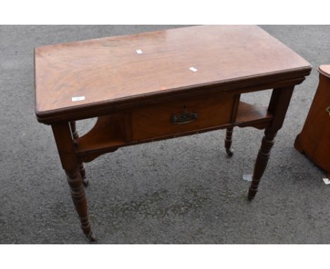 A Victorian fold over card table having frieze drawer and under shelf