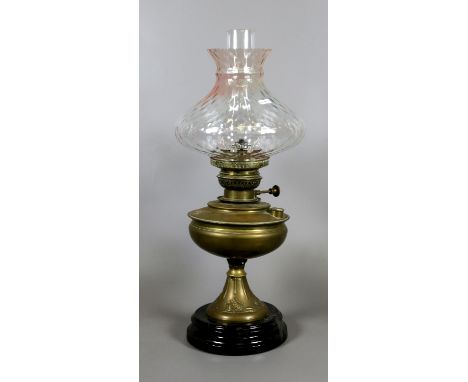 A Victorian brass based oil lamp with glass shade and chimney.