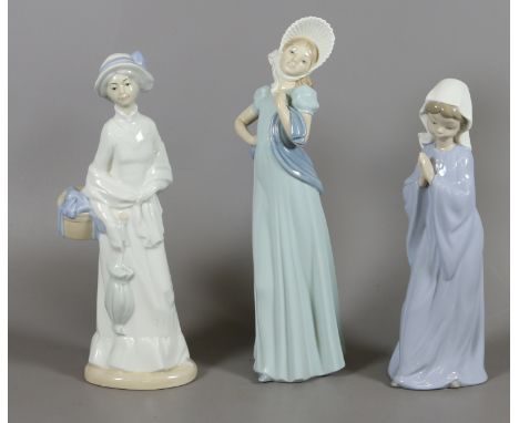 Two Nao figurines depicting lady with bonnet and young girl praying with another similar figure.