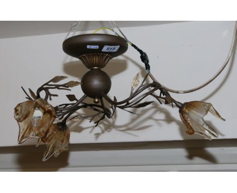 A brass three branch ceiling light formed as a flower with brown tinted glass shades.
