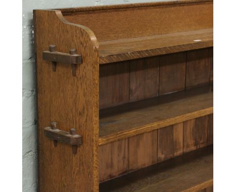 An Arts and Crafts oak five shelf bookcase, peg construction.