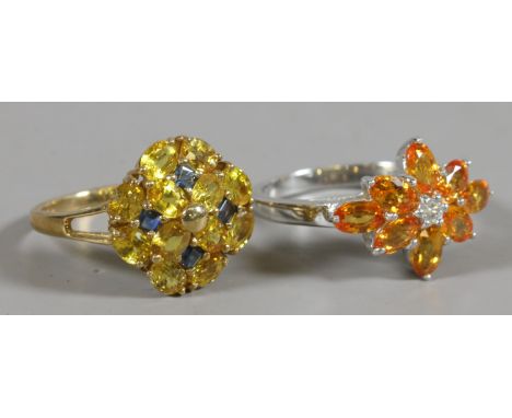 A 9 carat gold blue and yellow sapphire cluster ring and a 9 carat white gold orange sapphire ring. Gross weight 7.17 grams, 