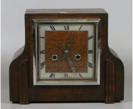 An oak cased mantel clock with part silvered dial and pendulum.