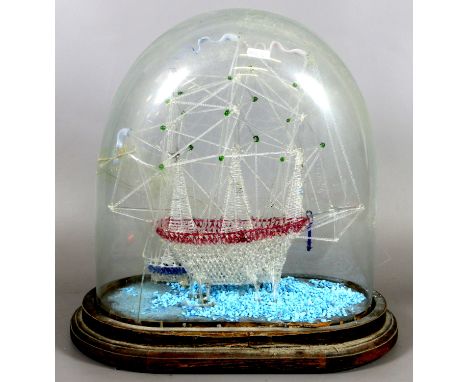 A Victorian spun glass model of a ship under a glass dome.