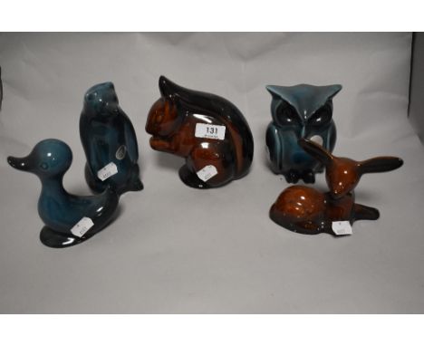 A menagerie of ceramic animals in blue and brown glazes, comprising; duck, deer, owl, squirrel and bear.