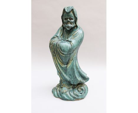 Chinese ceramic sculpture of a guardian in folded mantle on cloud, hand formed with blue glaze Qing Dynasty , 50 cm high