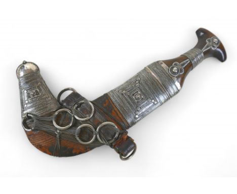 An Omani silver Khanjar dagger, with rhino horn handle, late 19th / early 20th century, with J shape steel blade, T shape hor
