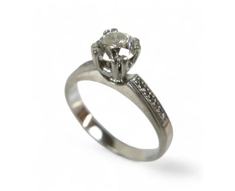 A platinum and diamond solitaire ring, the central 1ct brilliant cut diamond, colour H, clarity SI1, flanked either side by s