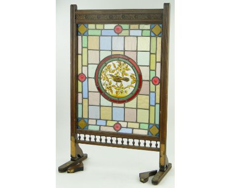 A Victorian carved oak framed fire screen,
with inset stained glass lead light panel and central painted glass panel depictin