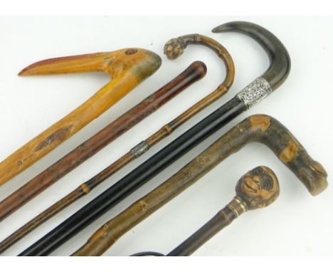 A Russian walking stick,
an umbrella with carved monkey head knop, a horn handled walking stick with silver collar and 3 othe