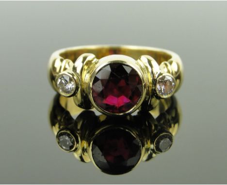 An 18ct gold 3 stone ruby and diamond ring,
ruby 6mm across, 7.3g, size K.