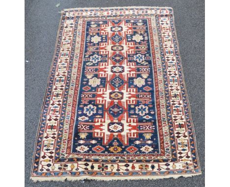 A red, blue and ivory ground Persian rug,
with symmetrical decorated borders and lozenge panel, 7'4" x 4'3".