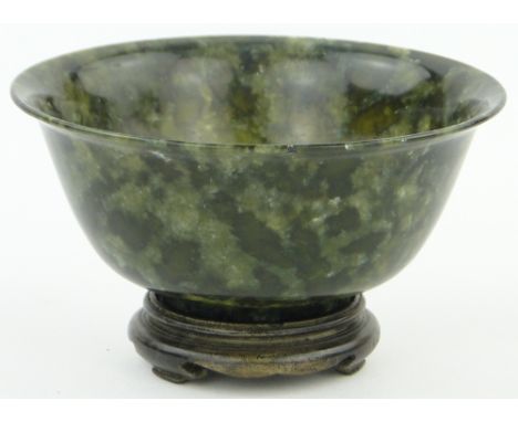 A Chinese spinach jade bowl,
with flared rim, 5" across, on carved hardwood stand