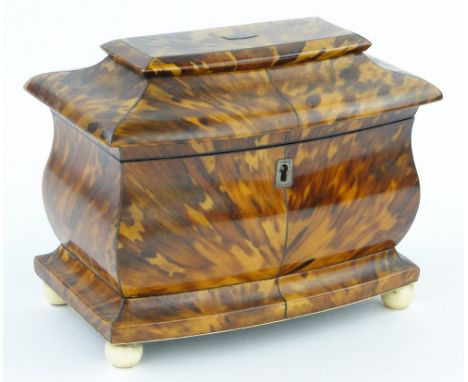 A 19th century blonde tortoiseshell sarcophagus shaped tea caddy,
with original inner lids and ivory bun feet, width 7.5".