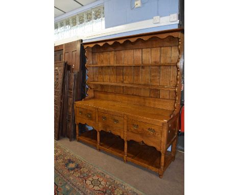 A good quality reproduction Georgian style oak dresser with two shelf back over a base section with three drawers and a pot b