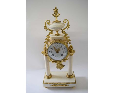 Mantel clock in French Empire style with alabaster columns on rectangular alabaster style base, painted dial with gilt hands,