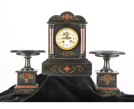 A Victorian slate mantle clock and garniture, the clock, 33cm high, and having red columns to front with an eight day drum mo