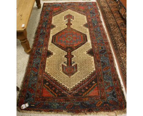 A Caucasian rug, the central panel set with lozenge shaped medallion on a fawn ground within a stepped red, blue and green ge